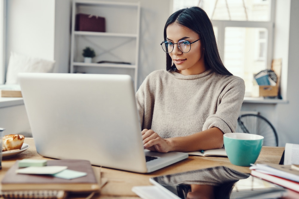 finance and investment assistant with glasses busy on laptop