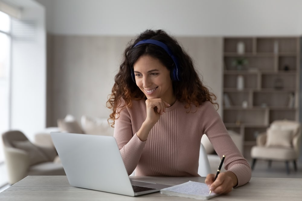 a woman smiling watching her laptop in e-commerce