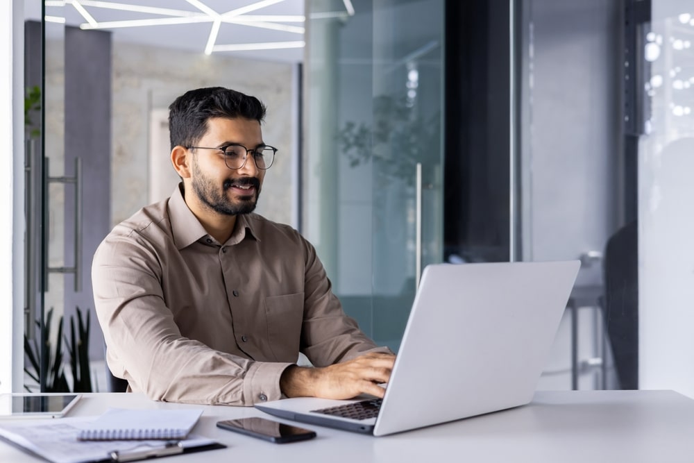 a design and creative virtual assistant sitting on the table using his laptop