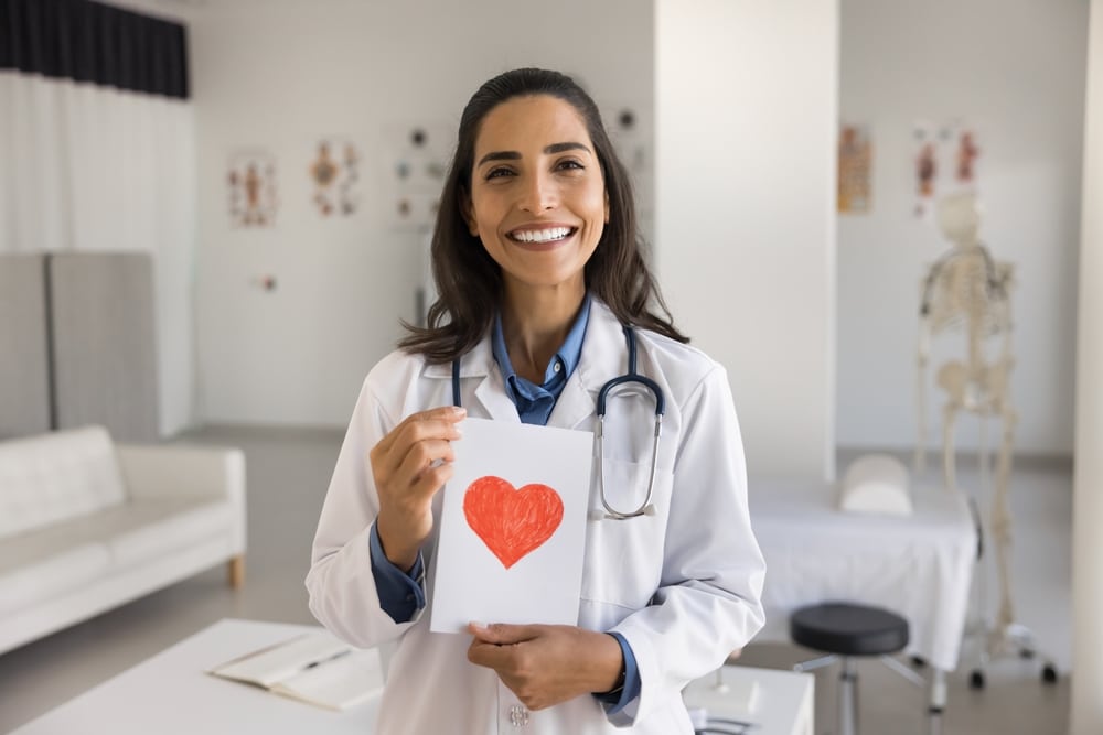 medical va female holding paper with a heart