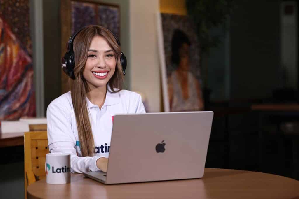 a virtual assistant smiling in front of her laptop