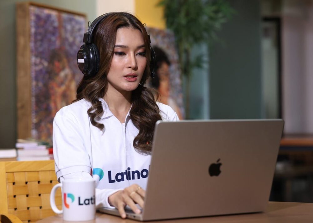 A focused woman in headphones working on her laptop, serving as an administrative virtual assistant