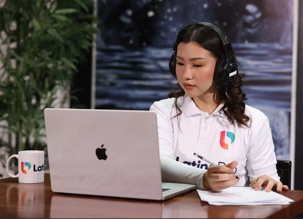 Focused Legal Assistant and Paralegal with headphones, diligently working on a laptop and taking notes