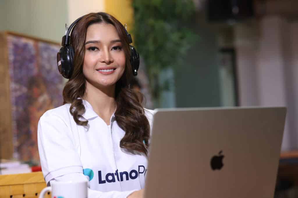 Professional woman with headphones and laptop, embodying an executive assistant job description.
