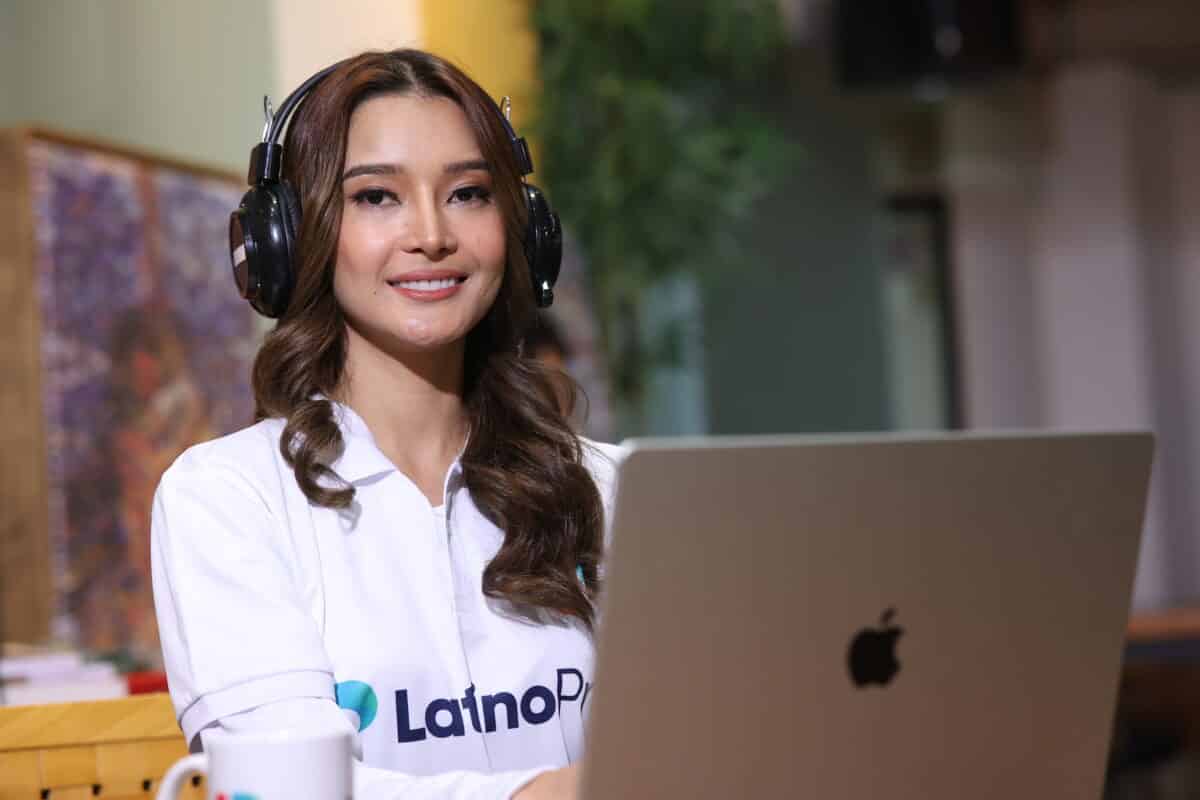 Professional woman with headphones and laptop, embodying an executive assistant job description.