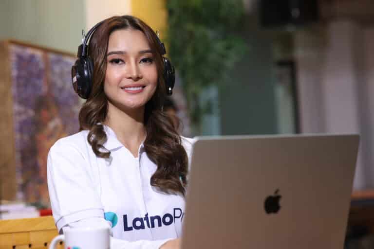 Professional woman with headphones and laptop, embodying an executive assistant job description.