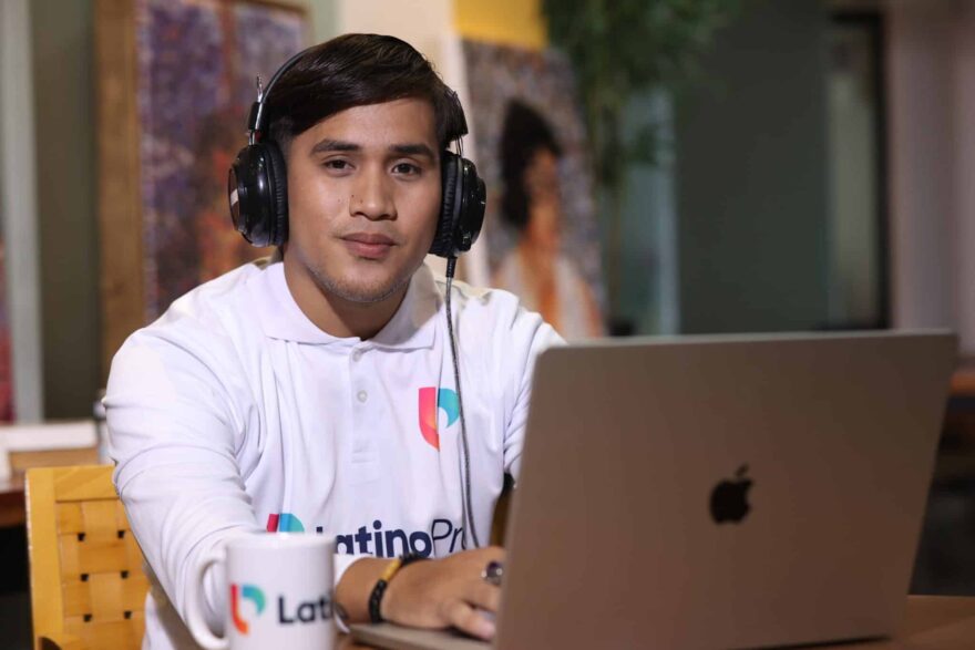 Confident professional with headphones and laptop, representing what a medical scribe does.