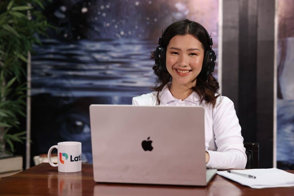 Smiling woman with headphones and laptop. Discover why you need a Design and Creative virtual assistant today
