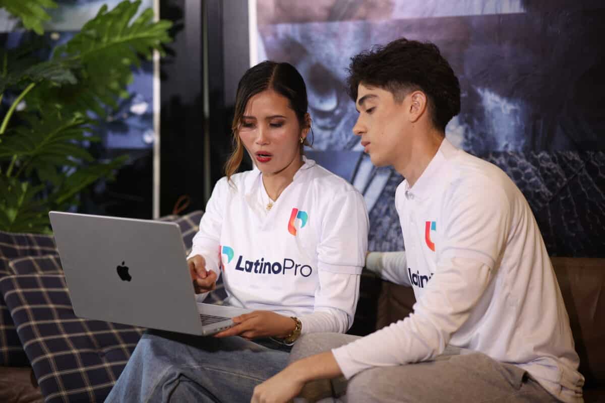 Two LatinoPro team members review data on a laptop, discussing what is case manager roles in client support strategy.