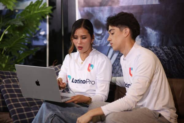 Two LatinoPro team members review data on a laptop, discussing what is case manager roles in client support strategy.