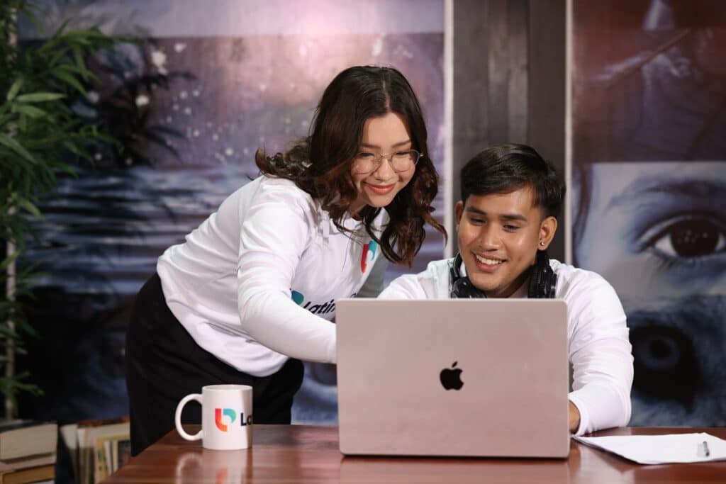 Two people collaborating on a laptop, smiling. The perfect fit for design and creative agencies