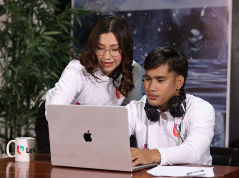 Two professionals collaborating on a laptop, performing administrative virtual assistant duties efficiently