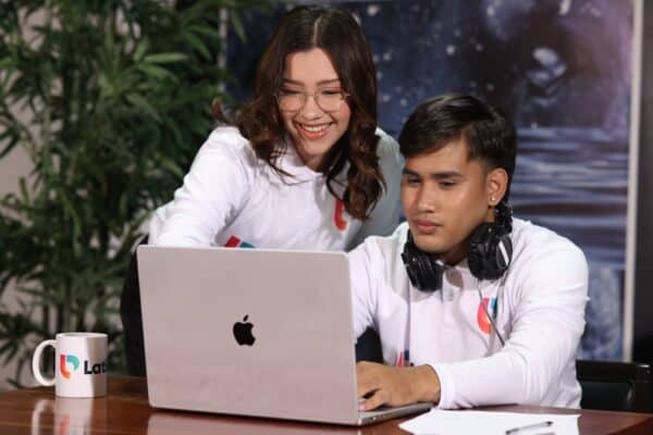 Two real estate virtual assistants collaborate on a laptop, demonstrating what do real estate virtual assistants do