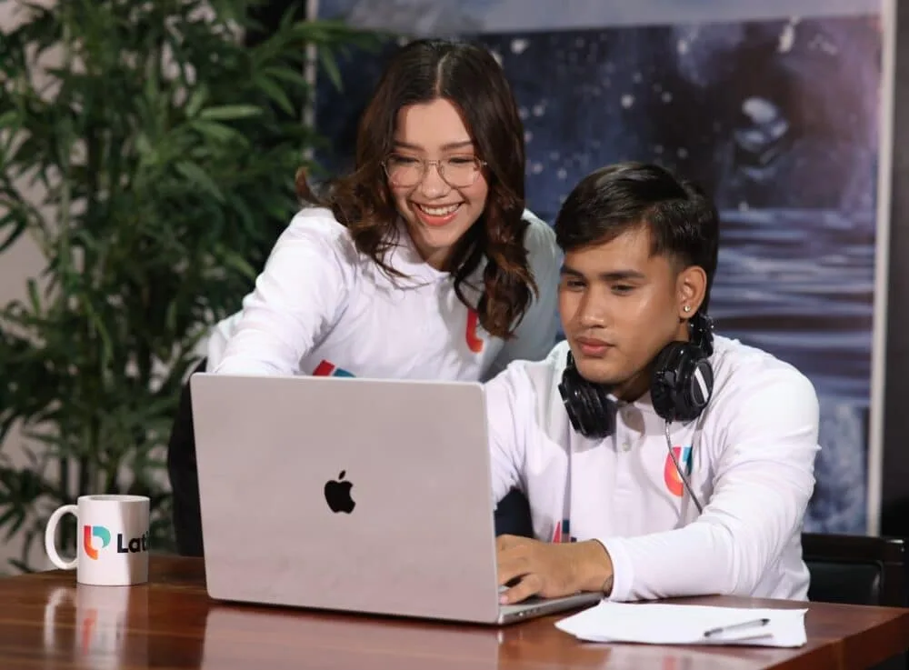 Two real estate virtual assistants collaborate on a laptop, demonstrating what do real estate virtual assistants do