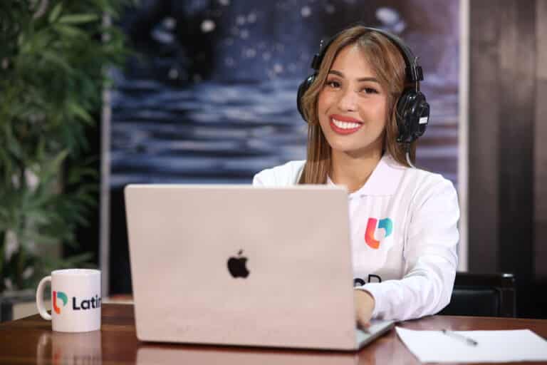 Woman smiling at desk with laptop, embodying efficient operations assistant work.