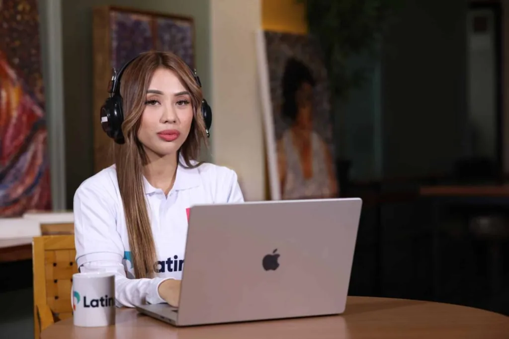 Woman with headphones working on laptop, representing what a medical scribe does.