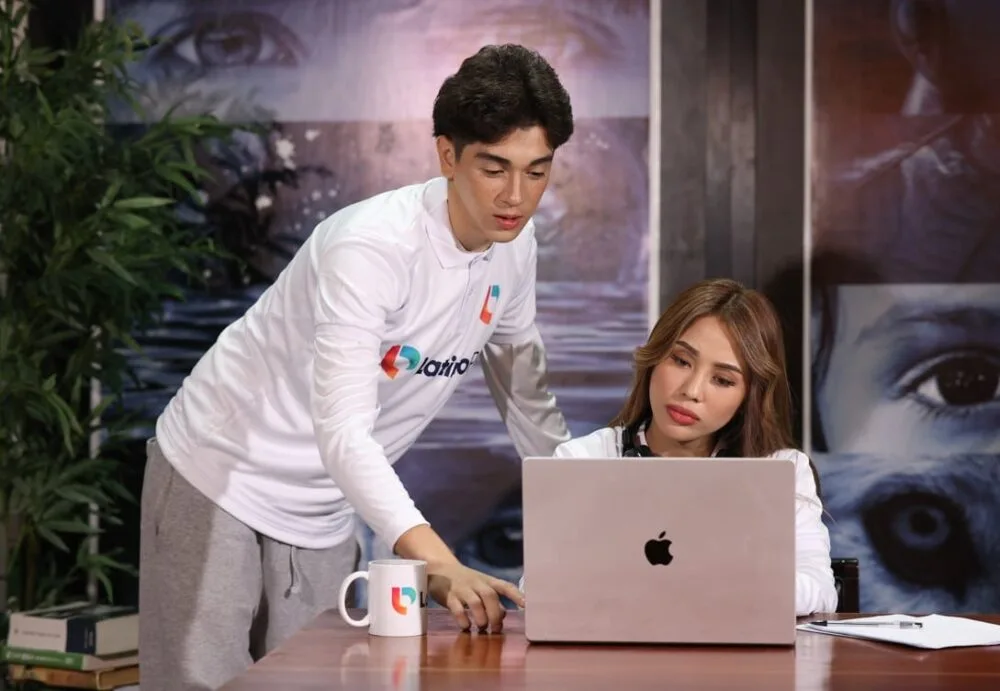 A man and woman look at a laptop. Learn how a legal assistant can become a lawyer with our program.