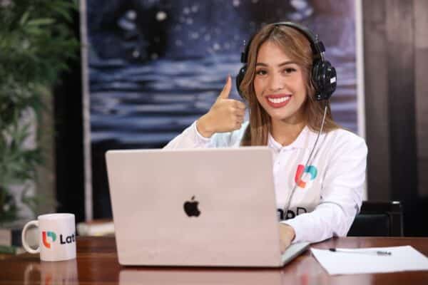 A smiling woman giving a thumbs-up while working on a laptop. Enjoy the many virtual legal assistant benefits with us