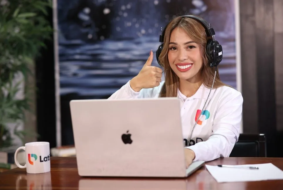 A smiling woman giving a thumbs-up while working on a laptop. Enjoy the many virtual legal assistant benefits with us