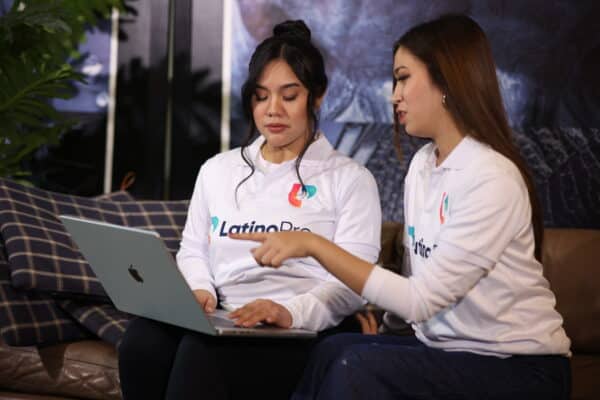 Legal and administrative assistant team from LatinoPro collaborating on tasks using a laptop in a remote work setting.