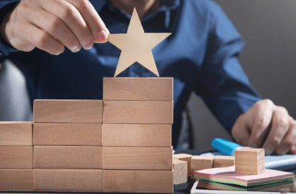 Man arranging blocks and stars to symbolize growth in legal transcriptionist work success.