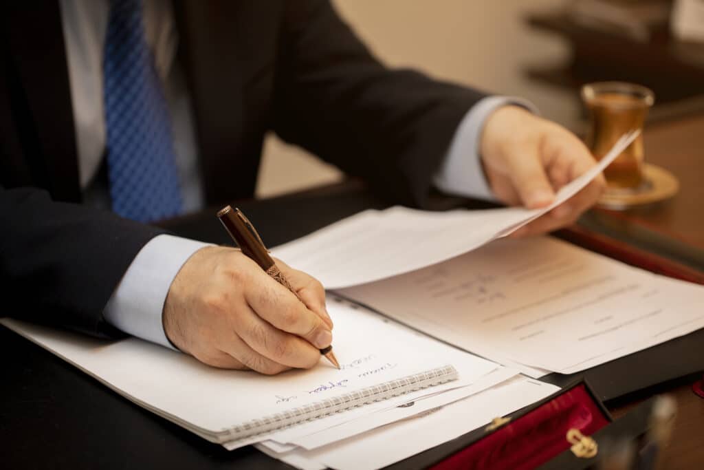 Professional reviewing documents and writing notes, representing efficiency in outsourced legal intake services.