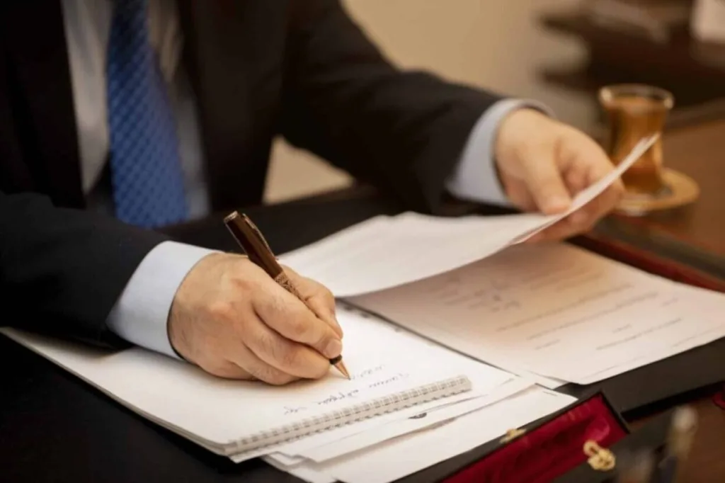 Professional reviewing documents and writing notes, representing efficiency in outsourced legal intake services.