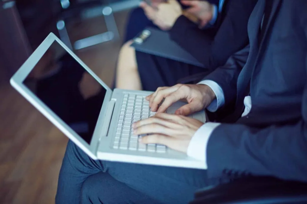 Professional-typing-on-laptop-during-meeting-showing-why-virtual-legal-assistants-important-in-law-firms-scaled-e1756271228348