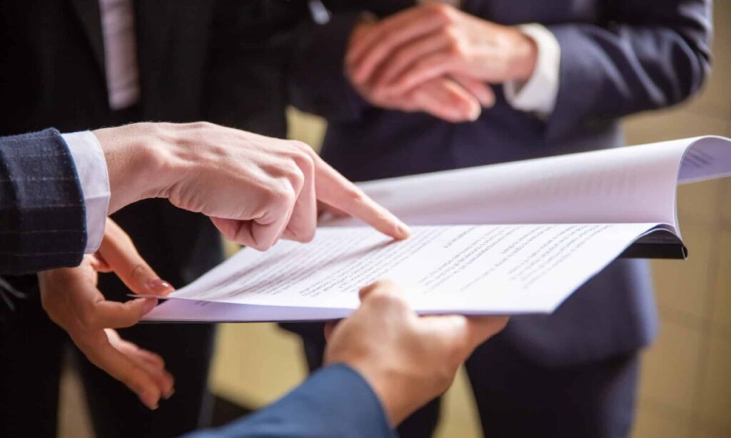 Professionals reviewing documents, illustrating legal assistant vs legal secretary roles in workplace collaboration.
