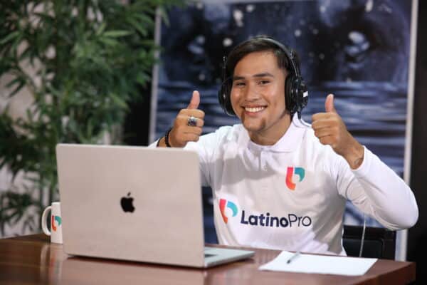 Smiling professional giving thumbs up while showcasing administrative assistant hard skills in a remote LatinoPro setup.