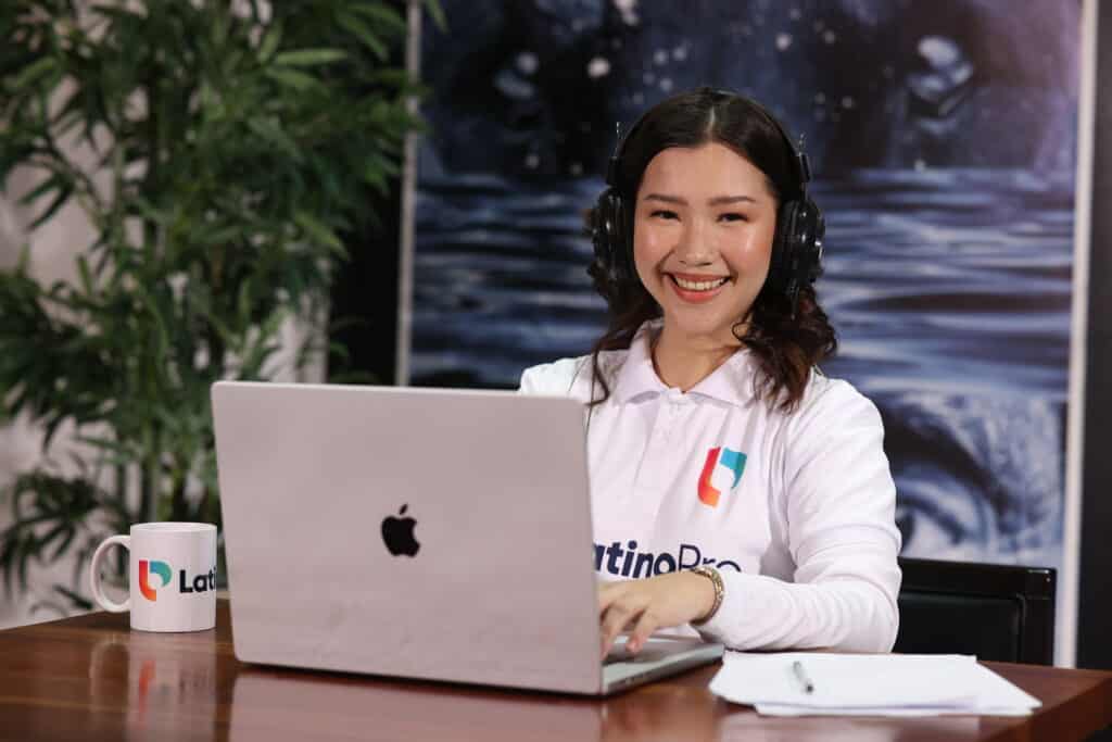 Smiling professional using a laptop and headset, representing virtual legal assistant services for law firms.