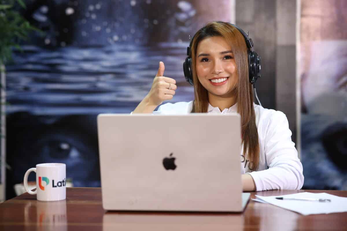 Smiling woman at laptop wearing headset, ready to assist—ideal visual for legal intake specialist job description page.