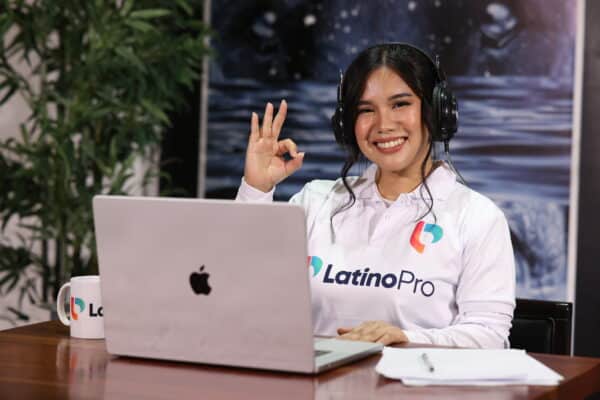 Smiling woman in headset and LatinoPro shirt on video call, illustrating what is a legal intake specialist in action.