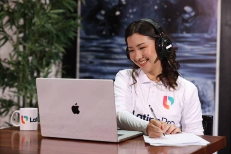 Smiling woman taking notes while learning how to become a legal transcriptionist during an online training session.