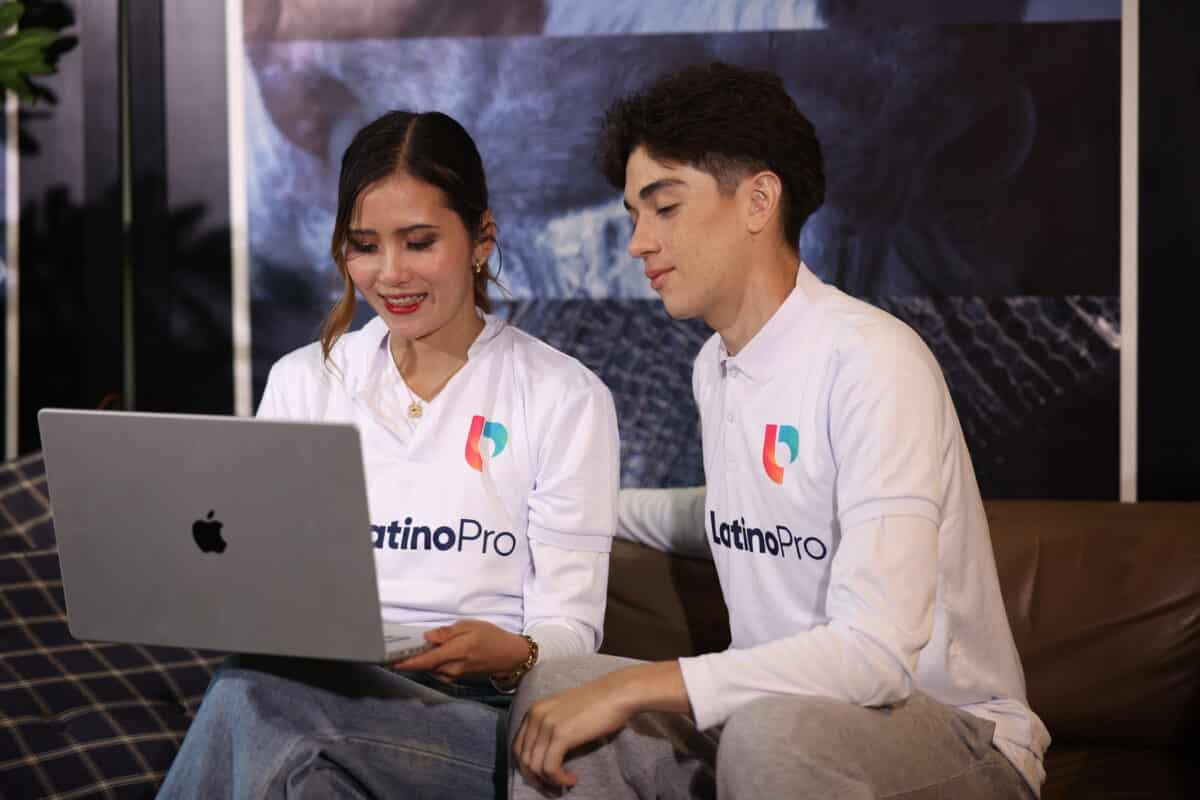 Two colleagues at LatinoPro reviewing accounting interview questions and answers on a laptop.