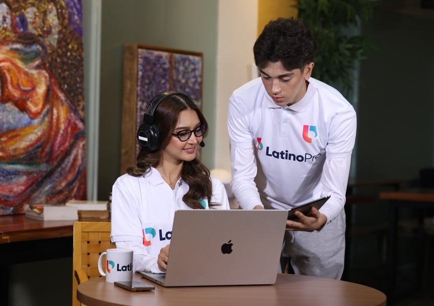 Two people collaborating on a laptop, with one person wearing a headset. Apply now to become a remote medical interpreter​