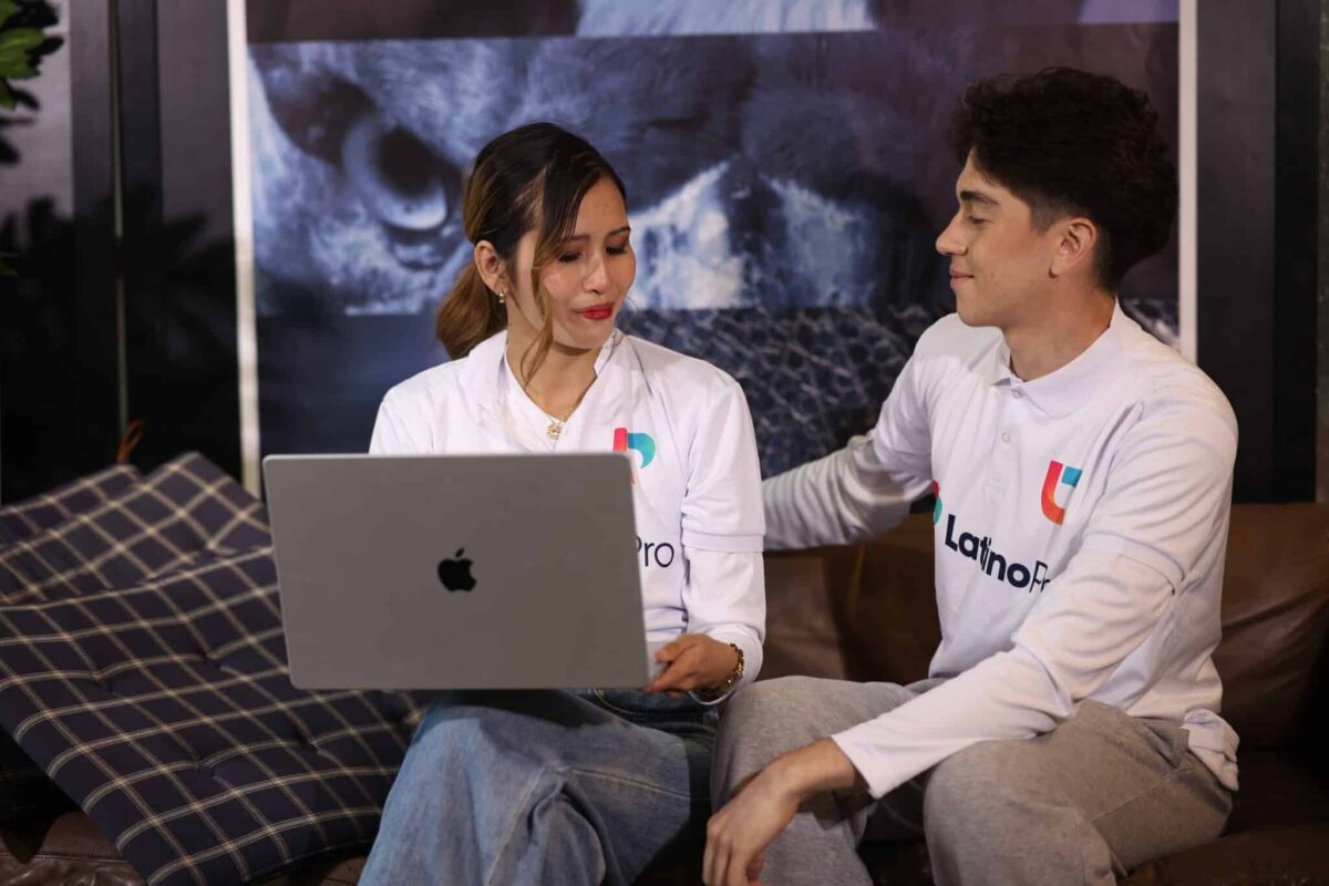 Two professionals in LatinoPro shirts discussing work on a laptop about accounting interview questions and answers.