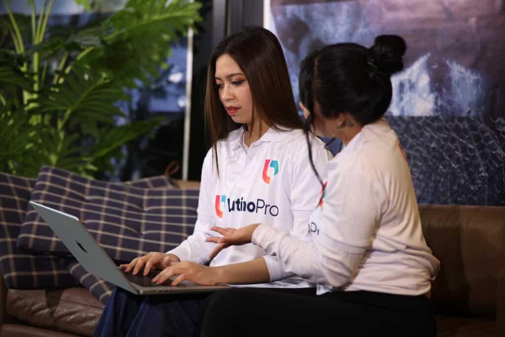 Two specialists discuss work on laptop, showing how do document review specialists virtual assistant operate in law firms