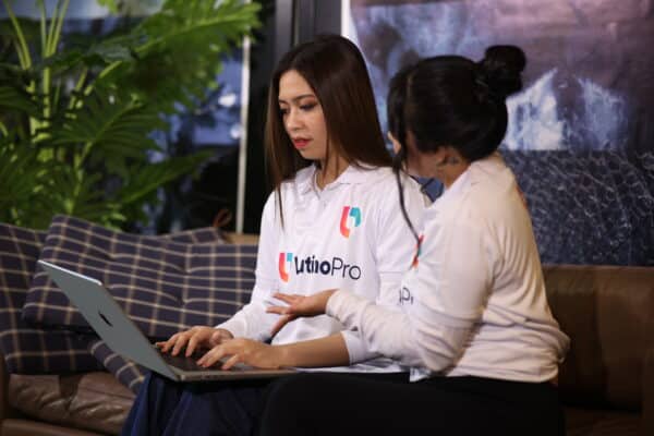 Two specialists discuss work on laptop, showing how do document review specialists virtual assistant operate in law firms